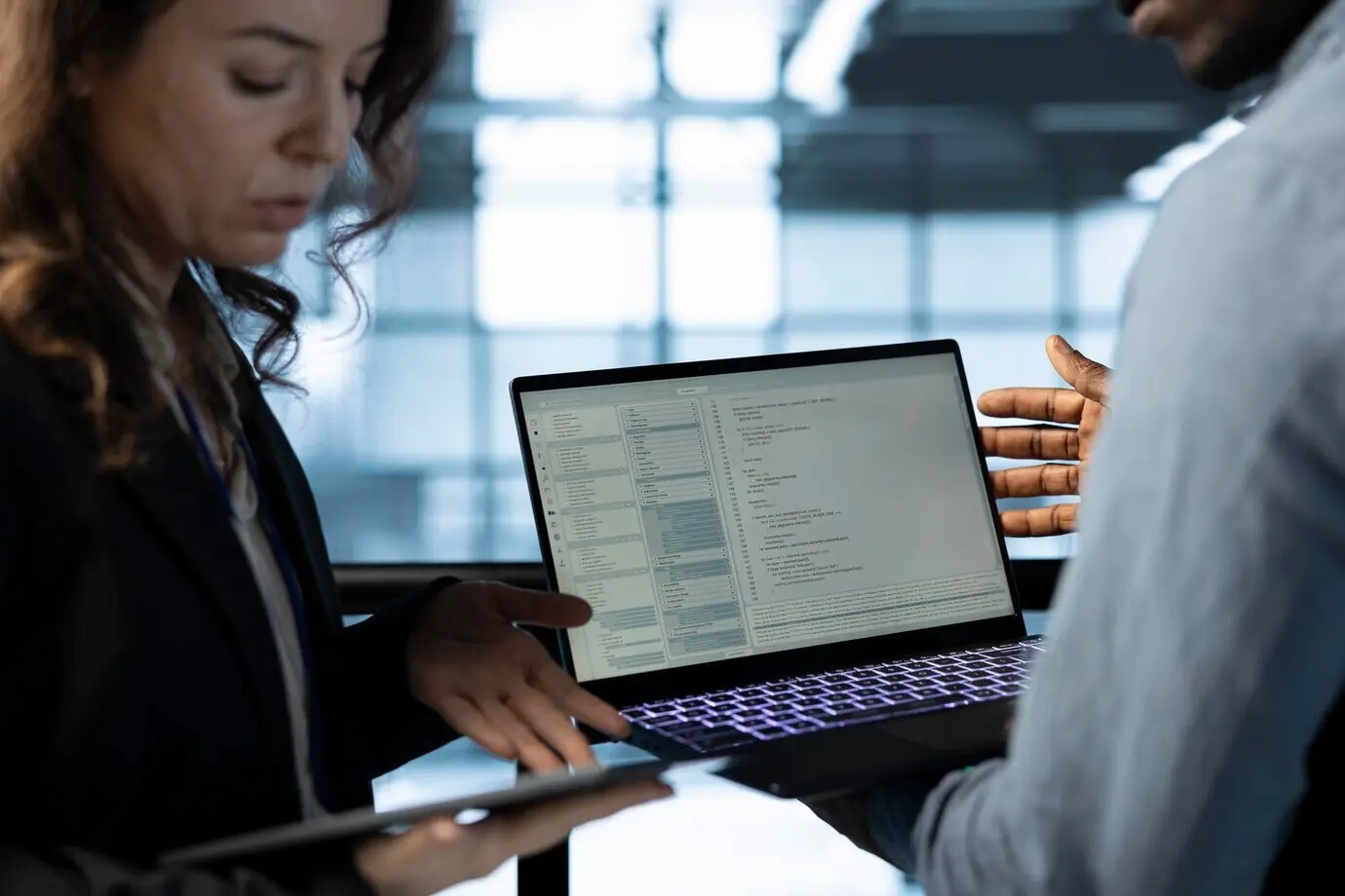 Softwareentwickler im Arbeitsbereich eines Rechenzentrums verwenden einen Laptop, um den Energieverbrauch zu kalibrieren.