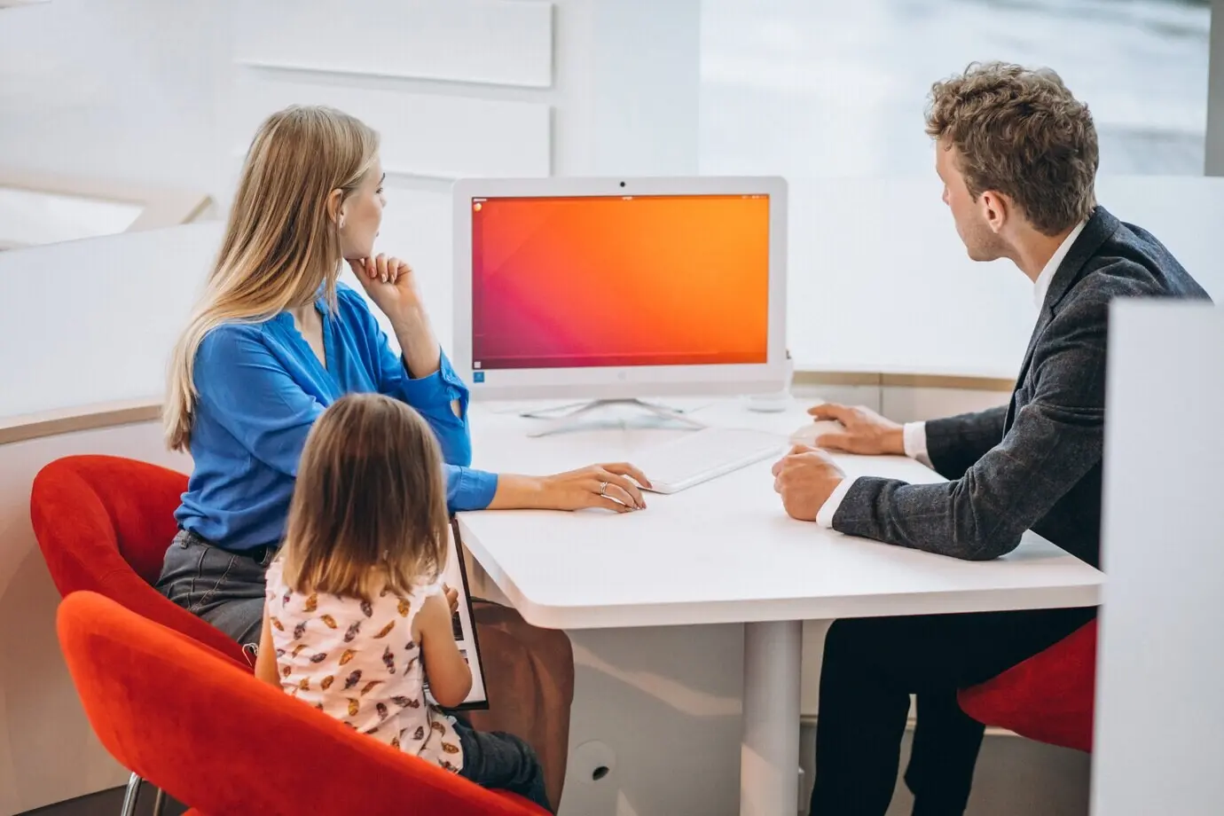 Mutter mit Tochter beim Autokauf in einem Auto-Showroom.